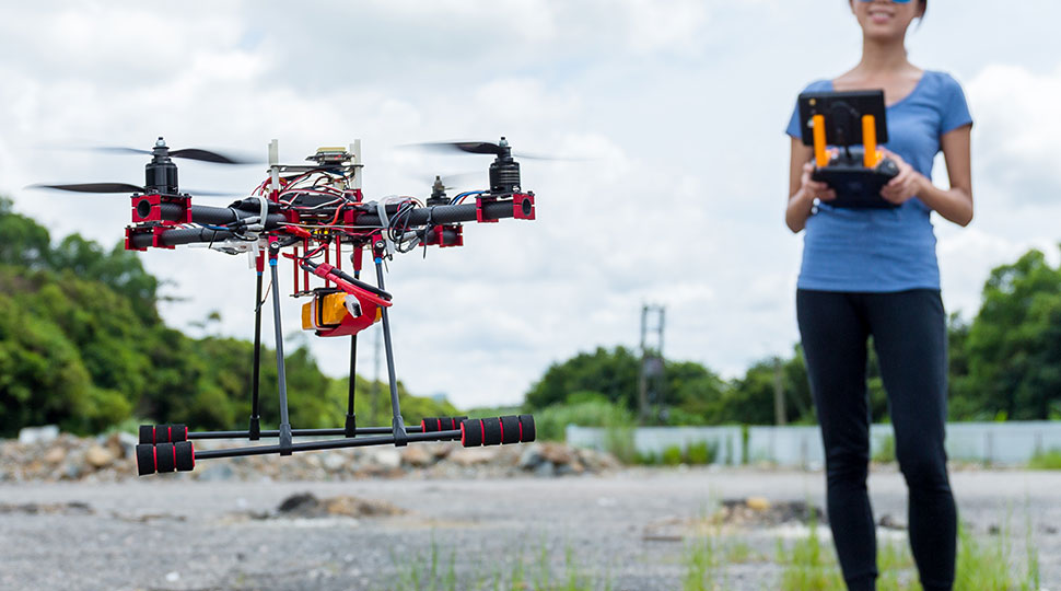 drone customization - woman using drone outdoors - newtodrones