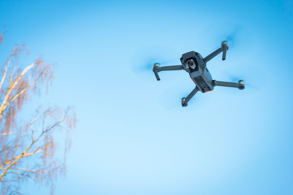 drone noise emission regulations - drone flying in blue sky - newtodrones