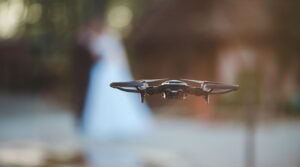 drone photography for events - closeup of drone with blurred newly weds - new to drones